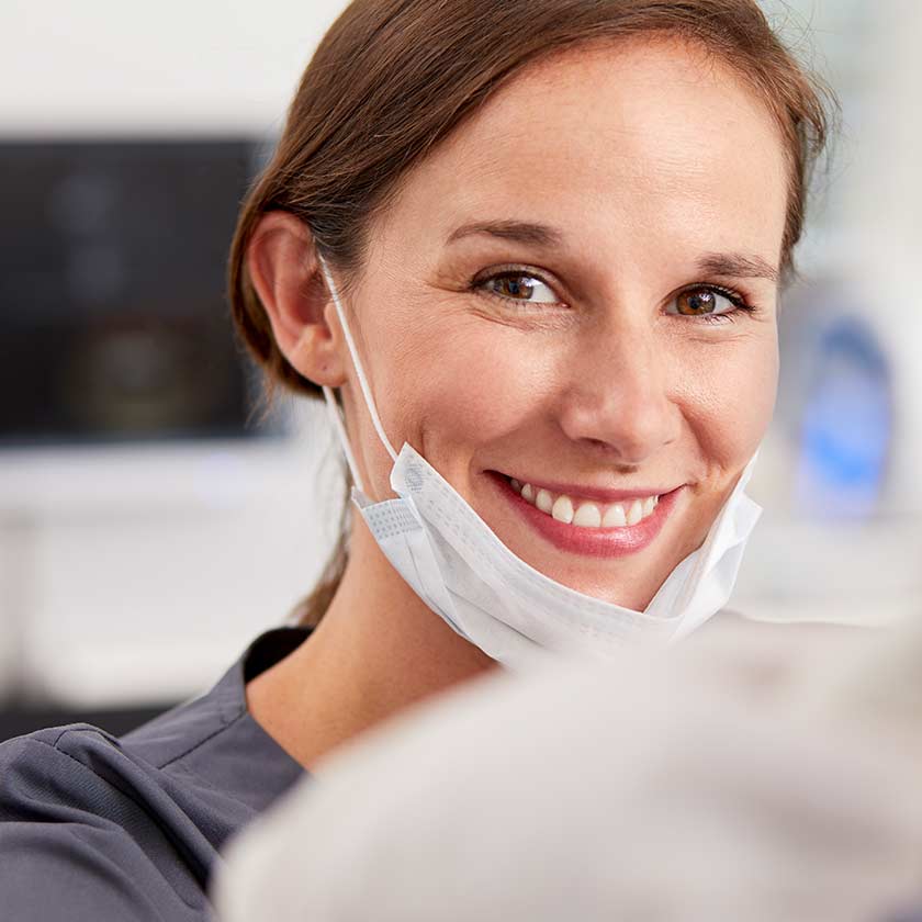 Lächelnde Patientin in einem der Behandlungszimmer der Wormser Zahnarztpraxis.