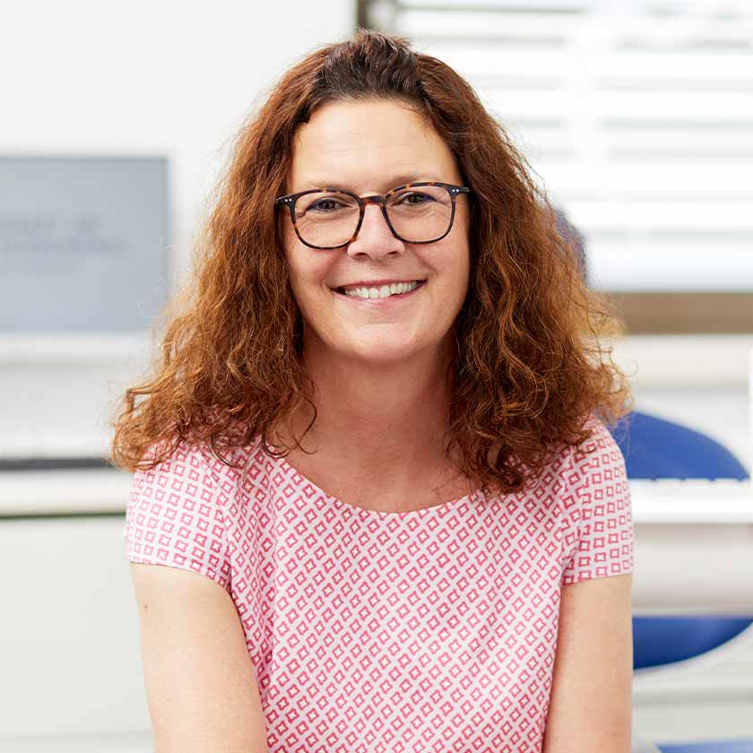 Lächelnde Patientin in einem der Behandlungszimmer der Wormser Zahnarztpraxis