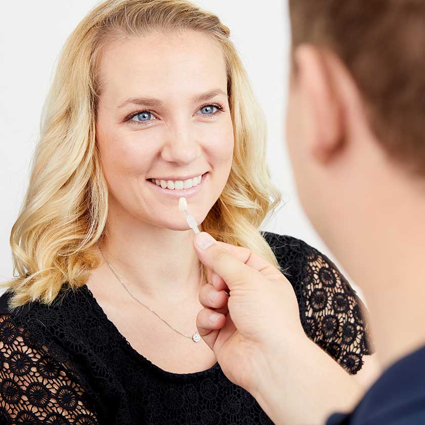 Dr. Schmidt berät Patientin zur Zahnfarbe für ihre Bleaching-Behandlung. 