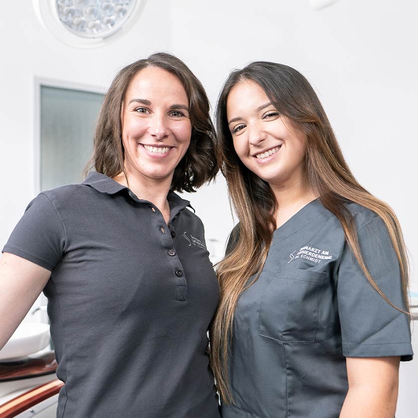 Zwei Lächelnde Mitarbeiterinnen der Praxis in einem Behandlungszimmer der Wormser Zahnarztpraxis
